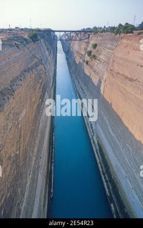 1986 der Kanal von Korinth Griechenland - der Kanal von Korinth verbindet den Golf von Korinth im Ionischen Meer mit dem Saronischen Golf in der Ägäis. Sie durchschneidet den schmalen Isthmus von Korinth und trennt den Peloponnes vom griechischen Festland. Der Kanal besteht aus einem einzigen Kanal 8 Meter (26 ft) tief, auf Meereshöhe ausgegraben. Die Felswände, die sich 90 Meter (300 ft) über dem Meeresspiegel erheben, befinden sich in einem nahezu vertikalen Winkel von 80 Grad. Korinth, Griechenland, EU, Europa Stockfoto