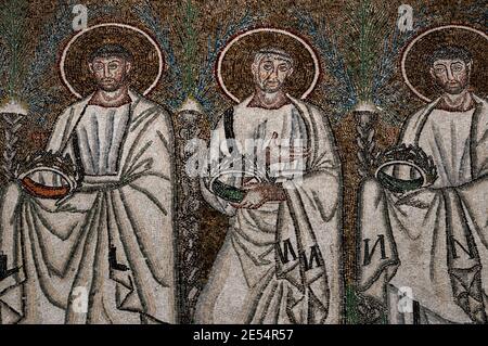 Drei von 26 männlichen christlichen Märtyrern gehen in einer Prozession. Detail aus dem byzantinischen Mosaik in der Basilica di Sant’Apollinare Nuovo in Ravenna, Emilia-Romagna, Italien. Das Mosaik entstand in den 500er Jahren n. Chr., wenige Jahre nachdem Ravenna von den Ostgoten erobert wurde. Stockfoto