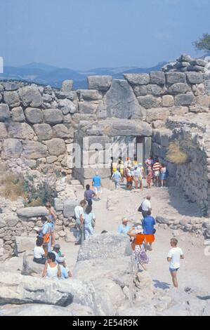 1986 Mycenae Griechenland - Mycenae Archäologische Stätte, Mycenae Löwentor und Zitadellenmauern, Mycenae, das Königreich von König Agamemnon, Herrscher der Griechen im Trojanischen Krieg. Die antike Stadt war von gigantischen Mauern umgeben, während der berühmteste Ort das Löwentor ist, der Eingang zur Stadt mit zwei weiblichen Steinlöwen darüber. Dies ist die Rückseite mit Touristen zu Fuß bis zur antiken Stadt, Archäologische Stätte der antiken Mykene, Mykene, Griechenland, EU, Europa Stockfoto