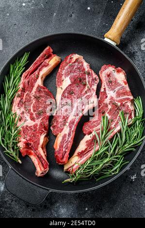 Frische Schnitte von rohem Rindfleisch Fleisch. Dunkler Holzhintergrund. Draufsicht. Stockfoto