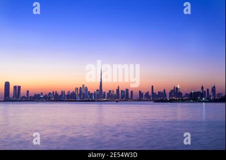 Panoramablick auf die Skyline von Dubai mit Burj khalifa und Andere Wolkenkratzer bei Sonnenuntergang mit der schönen gefangen Blauer Himmel am Dubai Creek Stockfoto