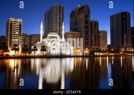 Blick auf die wunderschön beleuchtete Al Noor Moschee in der frühen Zeit sonnenaufgangsstunden, die Reflexionen im Wasser zeigen, das vom Al aufgenommen wurde Noor Island Sharjah Stockfoto