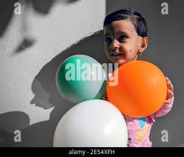 Kalaburagi, KarnatakaIndien-Januar 26 2021: Nahaufnahme eines indischen Mädchen, das mit bunten Luftballons spielt Stockfoto