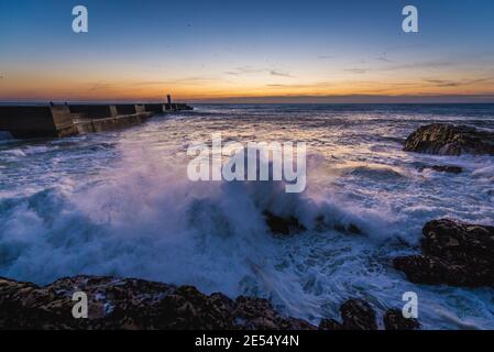 Sonnenuntergang über dem Atlantik. Ansicht mit kleiner Leuchtturm (Farolins Barra Douro) in Foz Douro Bezirk von Porto Stadt, Portugal Stockfoto