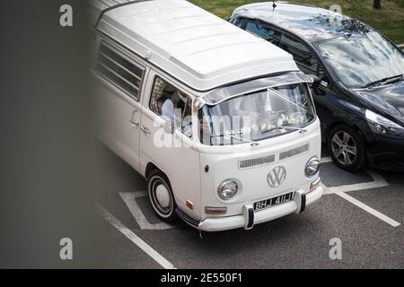 VW Wohnmobil Reflexion in Pfütze nach Regen weißes Wasser Gekühlte Bildschirm klassische Volkswagen Hochzeit Auto Creme Stahl Räder rot Polo Golf Spiegelbild Stockfoto