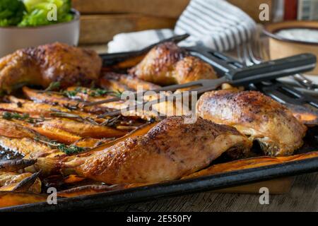 Gebratenes Hähnchen mit Süßkartoffelfrites auf einem Backblech Stockfoto