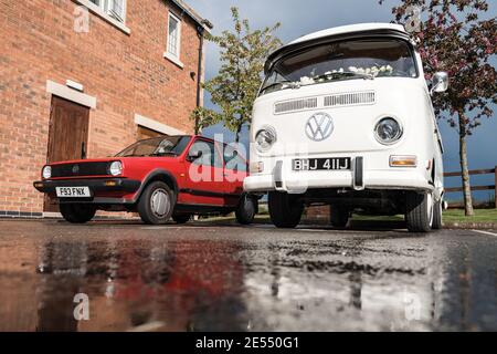 VW Wohnmobil Reflexion in Pfütze nach Regen weißes Wasser Gekühlte Bildschirm klassische Volkswagen Hochzeit Auto Creme Stahl Räder rot Polo Golf Spiegelbild Stockfoto