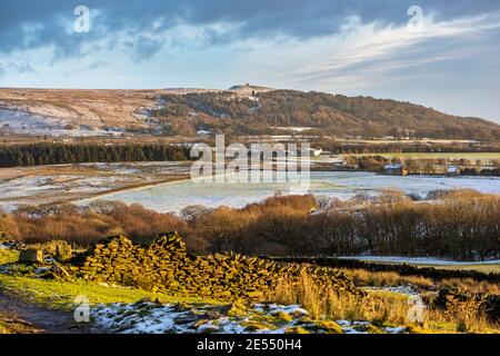 Winterszene bei Sonnenschein am späten Nachmittag über Rivington Moorland mit Blick auf Rivington Pike und Pigeon Tower Wahrzeichen. Lancashire UK Stockfoto