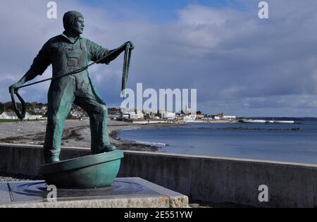 Die lebensgroße Bronzestatue eines Fischers mit Blick auf das Meer bei Newlyn in Cornwall. Errichtet in Erinnerung an alle kornischen Fischer, die los gewesen sind Stockfoto