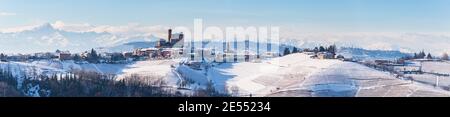 Italien Piemont: Weingärten einzigartige Landschaft Winter, Serralunga d'Alba mittelalterlichen Dorf Burg auf einem Hügel, die Alpen schneebedeckten Berge Hintergrund, Stockfoto