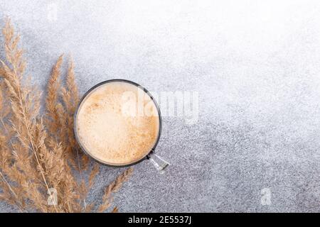 Tisch mit Tasse Kaffee und trockenen Blumen auf Stein Hintergrund. Arbeitsplatz, minimalistischer Stil, flach liegend, Draufsicht Home Office Schreibtisch - Bild Stockfoto