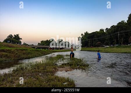 Prattville, Alabama, USA - 4. Juli 2017: Junge Jungs spielen in Autauga Creek, während sie auf das Feuerwerk am 4. Juli warten. Stockfoto