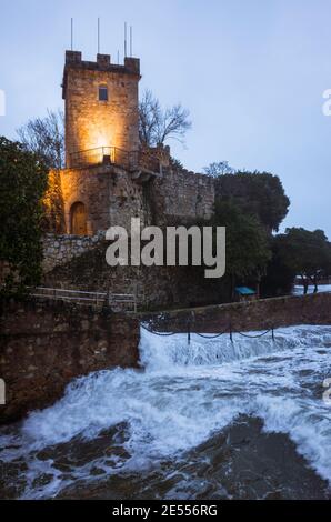 Oleiros, PROVINZ Coruña, Galicien, Spanien - 11. Februar 2020 : Wellen brechen gegen die Mauern der beleuchteten Burg Santa Cruz auf Santa Cristin Stockfoto