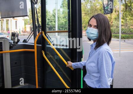 Almaty, Qazaqstan - 09. September 2020: Junge Frau mit einer schützenden medizinischen Gesichtsmaske in den Bus während eines Ausbruchs der covid-19 Stockfoto