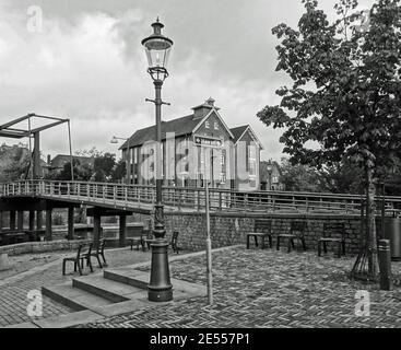 Alter Hafen von Coevorden, Niederlande. Wunderschöne alte Kanalhäuser, Lampenpfosten und eine alte Brücke. Schwarzweiß-Bild Stockfoto