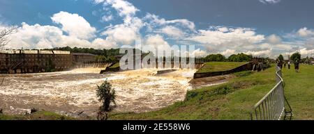 Prattville, Alabama, USA - 18. Juni 2017: Menschen stehen hinter einem Zaun, um die Überschwemmung auf dem Autauga Creek in der historischen Pratt Cotton Gin Mill zu sehen Stockfoto