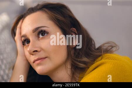 Junge hübsche Frau in Gedanken eingetaucht Stockfoto