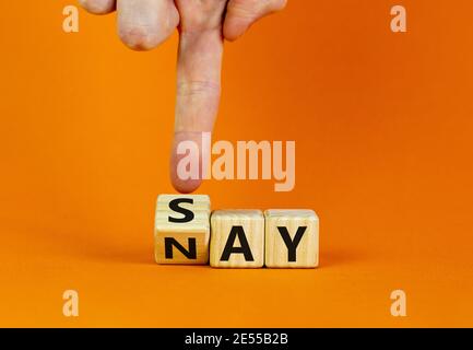 Sagen Sie das Nay-Symbol. Geschäftsmann dreht einen Würfel, ändert das Wort "Say" in "Nay". Schöner orangefarbener Hintergrund. Speicherplatz kopieren. Geschäft, Motivation und sagen, nein c Stockfoto