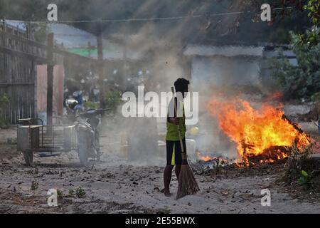 Chon Buri, Thailand - 16. Februar: Kambodschanische Arbeiter stehen am 16. Februar 2015 vor Bränden, wenn sie Abfälle im Arbeitsbereich verbrennen und vernichten. Stockfoto