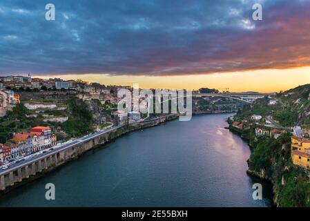 Spektakulärer Sonnenaufgang über dem Douro-Fluss, der Porto und Vila Nova de Gaia (rechts) in Portugal miteinander verband. Blick auf die Infante D. Henrique Brücke Stockfoto