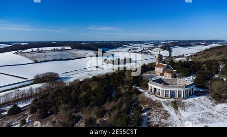 Luftdrohnenaufnahmen von verschneiten West Wycombe St Marys Church und dem Mausoleum im Winter, Buckinghamshire, England Stockfoto