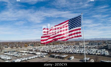 Große amerikanische Flagge fliegt über einer Stadt Stockfoto