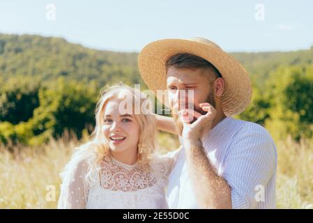 Glücklicher Landjunge im Hut steht mit seiner Geliebten Freundin im Sommer Stockfoto