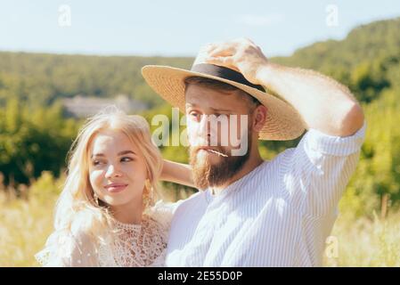 Glücklicher Landjunge im Hut steht mit seiner Geliebten Freundin im Sommer Stockfoto