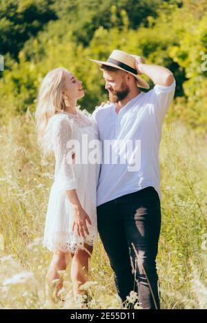 Glücklicher Landjunge im Hut steht mit seiner Geliebten Freundin im Sommer Stockfoto