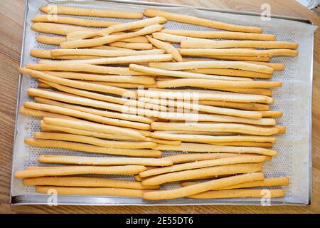 Frisch gebackene knusprige Brotstäbchen in einem Korbkorb zum Verkauf in einer Bäckerei, Draufsicht Stockfoto