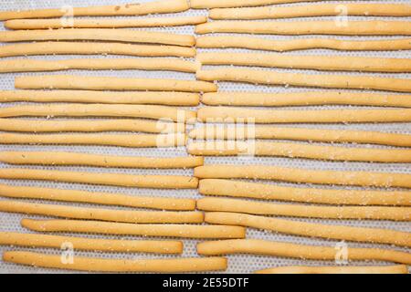 Frisch gebackene knusprige Brotstäbchen in einem Korbkorb zum Verkauf in einer Bäckerei, Draufsicht Stockfoto