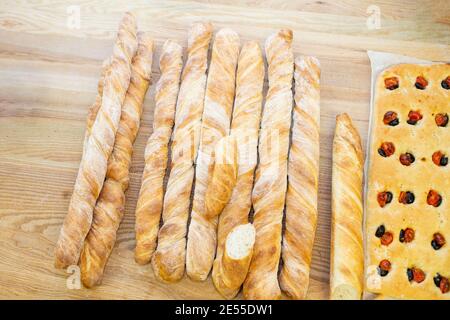 Köstliches frisch gebackenes Brot auf Holzhintergrund mit Focaccia, Draufsicht Stockfoto
