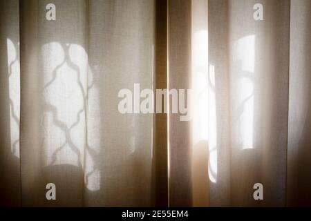 Spiegelung eines Fensters auf einem beigen Vorhang. Haus und Hotel. Stockfoto