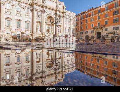 Im Winter bilden häufige Regenschauer Pools, in denen sich die wunderbare Altstadt Roms wie in einem Spiegel spiegelt. Hier ist der Trevi-Brunnen Stockfoto