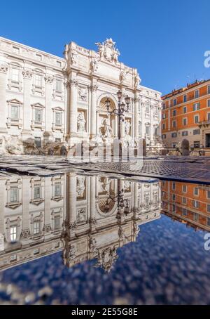 Im Winter bilden häufige Regenschauer Pools, in denen sich die wunderbare Altstadt Roms wie in einem Spiegel spiegelt. Hier ist der Trevi-Brunnen Stockfoto