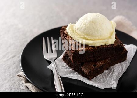 Brownie mit Vanilleeis Schaufel auf grauem Stein Stockfoto