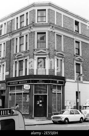 Großbritannien, West London, Notting Hill, 1973. Heruntergekommene und heruntergekommene, große, vierstöckige Häuser werden langsam restauriert und neu dekoriert. Ein Geschäft mit Lizenz an der Ecke Talbot Road (links) und Powis Square (rechts). Stockfoto