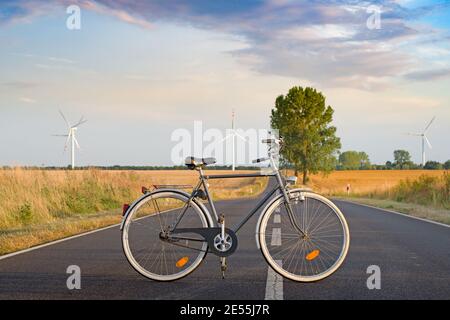 Die Menschen parken Fahrrad auf der Straße des Kraftwerks, die erzeugen Erneuerbare Energie aus Windenergieanlagen Stockfoto