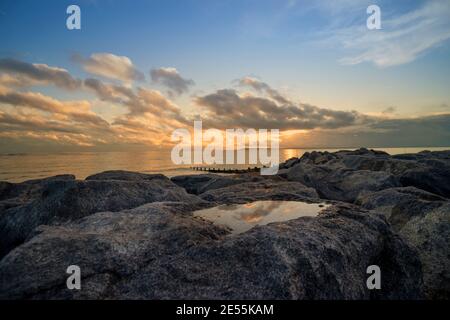 Sonnenuntergang über Felsen und Felsenpool auf Hayling Island, Hampshire, Großbritannien Stockfoto