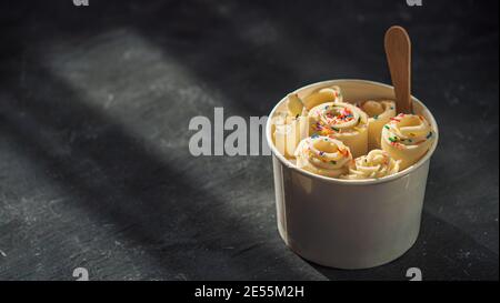 Gerollt Eis in Kegel Cup auf dunklen rustikalen Hintergrund. Vanille Eis Brötchen, Banner. Im thailändischen Stil gerollt Eis mit Kopie Platz für Text oder Design. Banner. Natürliche harte Tageslicht Stockfoto