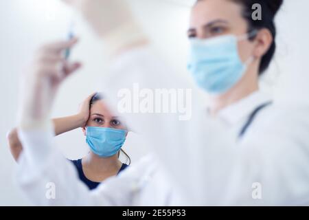 Hausarzt, der Patient in der Klinik impft. Arzt, der der älteren Frau im Krankenhaus eine Injektion verabreichung gab. Krankenschwester hält Spritze vor machen Covid-19 o Stockfoto