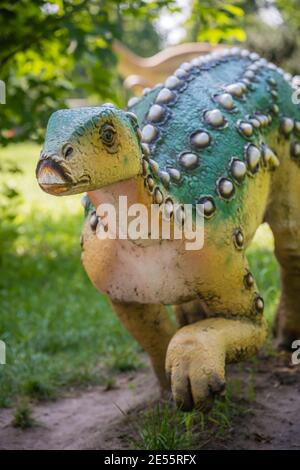 Vertikale Aufnahme einer Dinosaurierstatue in einem Park Stockfoto