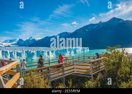 Der berühmte Perito Moreno Gletscher und die türkisfarbene Lagune mit australwäldern im goldenen Herbst in Patagonien, mit Touristen, die den Gletscher bei t beobachten Stockfoto