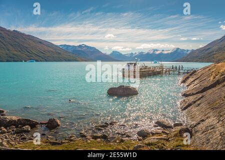 Panoramablick über türkisfarbene Wasser-Gletscherlagune vom gigantischen Perito Moreno Gletscher in Patagonien mit einem Ausflugsboot und Touristen an Bord, Süd A Stockfoto