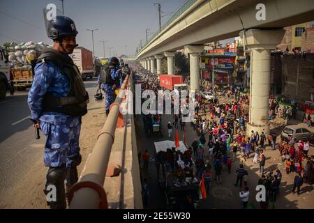 Ein Polizist sieht zu, wie Demonstranten an der Demonstration teilnehmen.Bauern, die gegen Agrarreformen protestierten, durchschlugen am 72. Tag der Republik Indiens Barrikaden und kolladierten mit der Polizei in der Hauptstadt. Die Polizei feuerte Tränengas, um sie zu vereifernden, kurz nachdem ein Konvoi von Traktoren durch die Außenbezirke von Delhi herumgetrompelt war. (Foto von Manish Rajput / SOPA Images/Sipa USA)