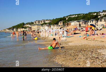 Junger Mann, der am Strand mit Shisha relaxt. Trouville-sur-Mer und das nahe gelegene Deauville sind beliebte Sommerresorts in der Normandie. Stockfoto