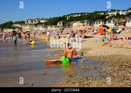 Junger Mann, der am Strand mit Shisha relaxt. Trouville-sur-Mer und das nahe gelegene Deauville sind beliebte Sommerresorts in der Normandie. Stockfoto