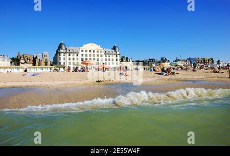 Die Leute entspannen sich am Strand. Trouville-sur-Mer und das nahe gelegene Deauville sind beliebte Sommerresorts in der Normandie Stockfoto