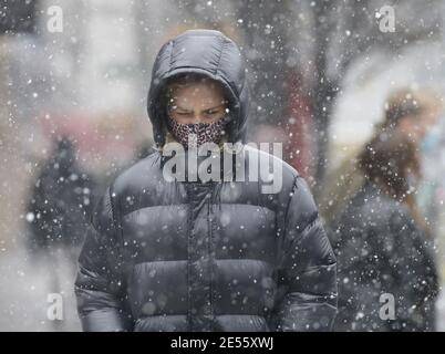 New York, Usa. Januar 2021. Fußgänger gehen bei kaltem Wetter gebündelt und tragen Gesichtsmasken, um vor der Ausbreitung von COVID-19 zu schützen und zu verhindern, wenn am Dienstag, 26. Januar 2021 in New York City Schnee fällt. Foto von John Angelillo/UPI Kredit: UPI/Alamy Live Nachrichten Stockfoto
