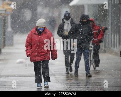 New York, Usa. Januar 2021. Fußgänger gehen bei kaltem Wetter gebündelt und tragen Gesichtsmasken, um vor der Ausbreitung von COVID-19 zu schützen und zu verhindern, wenn am Dienstag, 26. Januar 2021 in New York City Schnee fällt. Foto von John Angelillo/UPI Kredit: UPI/Alamy Live Nachrichten Stockfoto